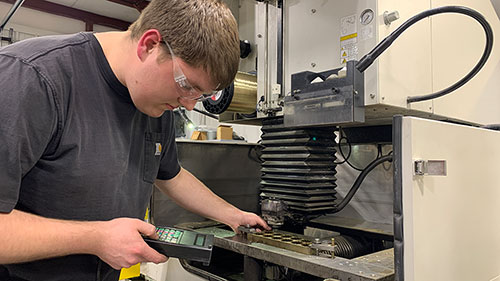 ARC EDM employee Derek Marcum sets up one of the wire EDM machines.